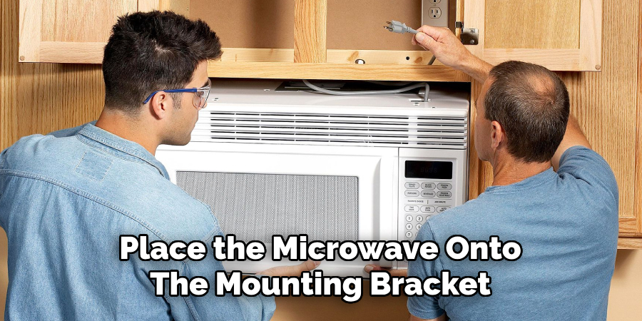 Place the Microwave Onto
The Mounting Bracket 